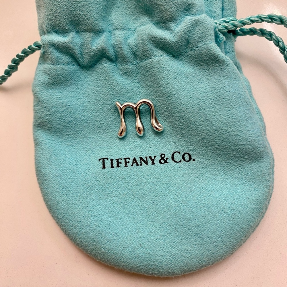Tiffany & Co. Elsa Peretti “M” pendant.